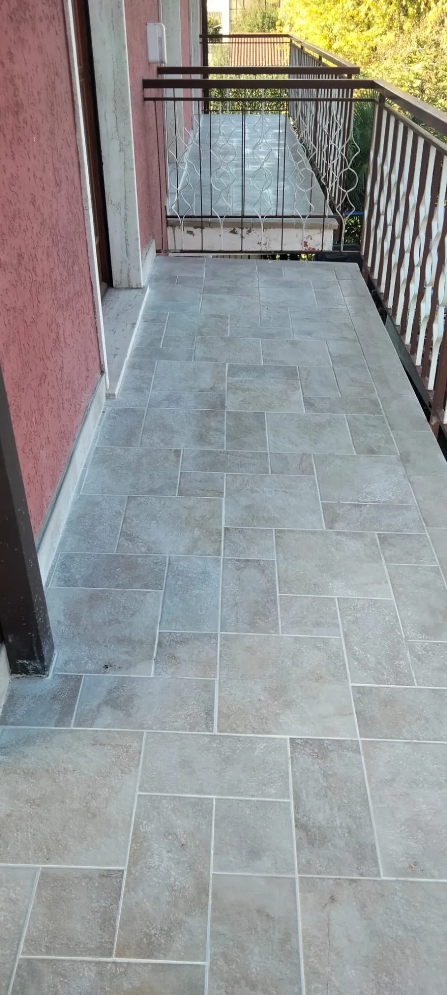 Pavimentazione di un balcone: piastrelle effetto pietra in più formati, posate per tutta la lunghezza del balcone