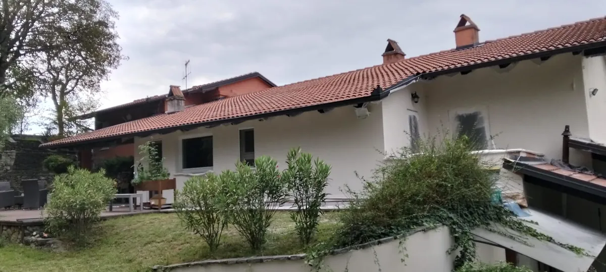 Facciata bianca di un'abitazione con tetto in coppi