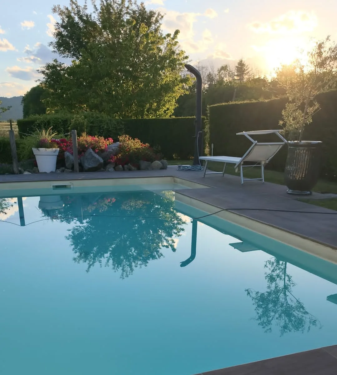 Pavimentazione a bordo piscina: bordo vasca e camminamento perimetrale in piastrelle effetto legno